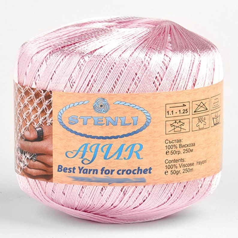 May include: A pink ball of yarn labeled "STENLI AJUR Best Yarn for crochet" with care instructions and composition information in both English and Russian. The yarn is 100% viscose and comes in a 50 gram, 250 meter skein.