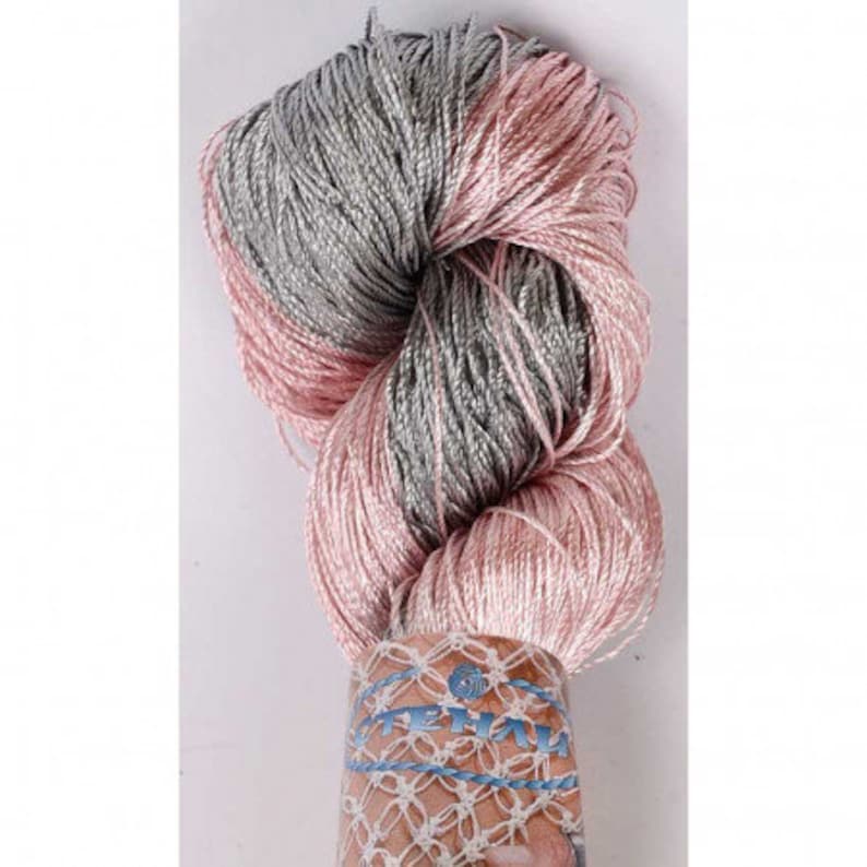 May include: A skein of yarn in a pink and gray color combination. The yarn is wrapped around a white label with the word "STEFAN" printed on it.