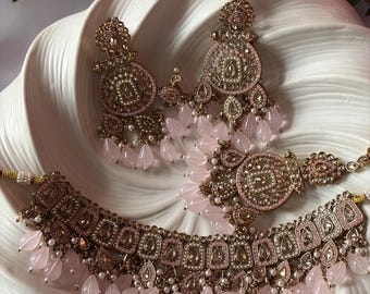 Conjunto de collar nupcial rosa rubor con tikka y joyas con perlas doradas.
