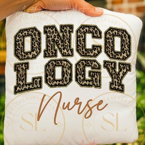 May include: A white square cushion featuring the word "ONCOLOGY" in large, leopard print letters with gold glitter edging. Below, the word "Nurse" is written in a brown, cursive font. The cushion is held by a hand.