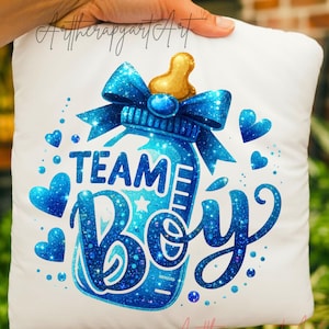 May include: White pillow with a blue baby bottle design. The bottle has a blue bow and the words "TEAM BOY" in blue glitter lettering. Blue hearts and a gold nipple complete the design.