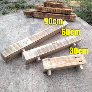 May include: Three rectangular wooden planters with a natural grain finish, each supported by small feet. The planters are labelled with lengths of 90cm, 60cm, and 30cm. The wood features visible knots and a light brown tone, arranged in a tiered display.
