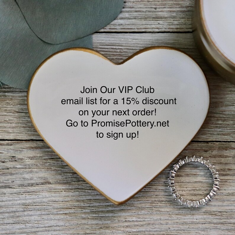 May include: White heart-shaped ceramic dish with a gold rim. The dish has text that reads "Join Our VIP Club email list for a 15% discount on your next order! Go to PromisePottery.net to sign up!"