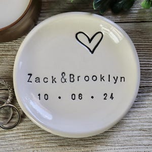 Puede incluir: Plato de cerámica blanco para anillos con un corazón dibujado a mano y el texto "Zack & Brooklyn 10.06.24".