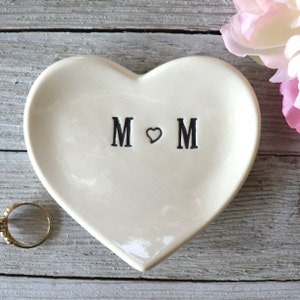 Puede incluir: Plato de cerámica blanco en forma de corazón con las palabras "M ♥ M" en letras negras.