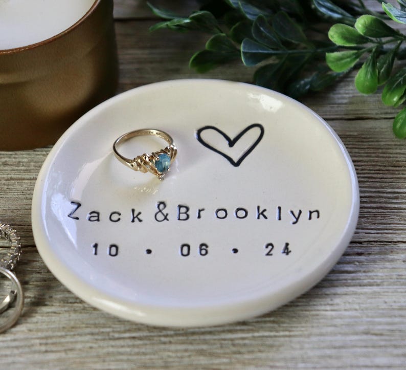 Op de afbeelding: Witte keramische ringenschotel met een handgetekend hart en de tekst "Zack & Brooklyn 10.06.24".