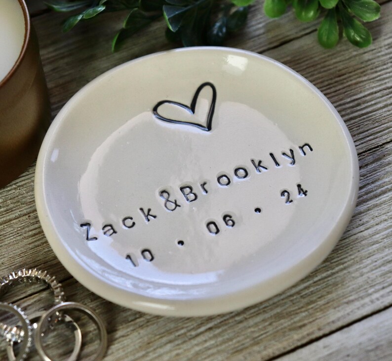 Op de afbeelding: Witte keramische ringenschotel met een handgetekend hart en de tekst "Zack & Brooklyn 10.06.24".