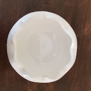 Puede incluir: Un taz&oacute;n de cer&aacute;mica blanco con un borde festoneado. El taz&oacute;n est&aacute; vac&iacute;o y tiene un acabado liso y brillante.