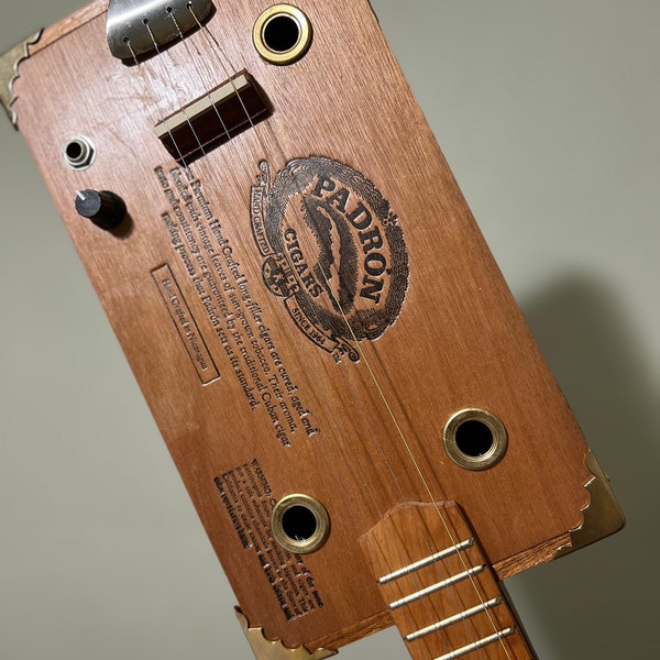 Zigarrenschachtelgitarre. KOSTENLOSER VERSAND! Akustisch/elektrisch! 4 Saiten. Perfekte Padron-Box. Padron ist die erste Wahl für Cigar-Box-Gitarristen