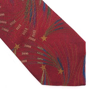 Puede incluir: Corbata roja con un patrón repetido del número "2000" y diseños de explosiones de estrellas en dorado, azul y verde. La corbata tiene un tejido texturizado.