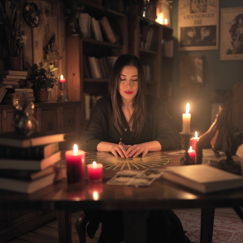 Puede incluir: Una mujer est&aacute; sentada en una mesa de madera, rodeada de velas y libros, con una tirada de cartas del tarot frente a ella. La habitaci&oacute;n est&aacute; tenuemente iluminada, creando una atm&oacute;sfera m&iacute;stica. La escena sugiere un entorno espiritual o de adivinaci&oacute;n.