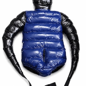 Op de afbeelding: Een blauw en zwart pufferjack met capuchon. De jas heeft een glanzend, gewatteerd ontwerp met zwarte mouwen en capuchon. Het heeft een zwart banddetail aan de onderkant.