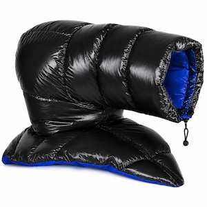 K&ouml;nnte beinhalten: Ein gl&auml;nzendes, schwarzes, gestepptes Puffer-Accessoire mit leuchtend blauem Innenfutter. Der Artikel hat eine r&ouml;hrenf&ouml;rmige, gepolsterte Konstruktion mit horizontalen N&auml;hten und einen schwarzen Kordelzugverschluss an der &Ouml;ffnung.