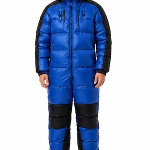 May include: A full-body insulated puffer jumpsuit in bright blue with black panels on the shoulders, sleeves, and legs. The garment features a front zip closure, a hood with drawstrings, and ribbed cuffs at the wrists and ankles.