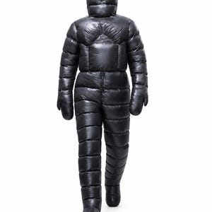 May include: A full-body black quilted down suit featuring a hooded top, long sleeves with integrated mittens, and full-length trousers. The garment has a shiny, smooth finish with horizontal baffle stitching throughout the entire piece.