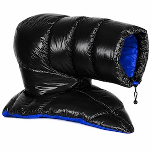 K&ouml;nnte beinhalten: Ein schwarzes, gestepptes Puffer-Accessoire mit gl&auml;nzender Oberfl&auml;che und leuchtend blauem Innenfutter. Der Artikel verf&uuml;gt &uuml;ber horizontale Kammern, eine strukturierte R&ouml;hrenform und eine schwarze Kordel mit Kunststoff-Stopper.