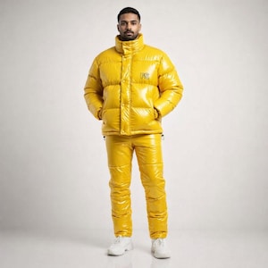 Puede incluir: Conjunto de chaqueta y pantalón acolchados de color amarillo brillante. La chaqueta tiene cuello alto, cierre de botones y las letras "PS" en el pecho. El pantalón tiene cintura con cordón. El conjunto se completa con zapatillas blancas.