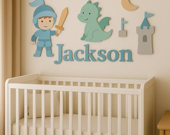 May include: A nursery wall decor set featuring a knight, dragon, castle, and moon, all in soft pastel colors. The name "Jackson" is spelled out in blue letters, creating a personalized touch above a white crib.