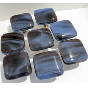 May include: Eight square glass cabinet knobs with a blue and brown swirl pattern. The knobs have a silver metal mounting.