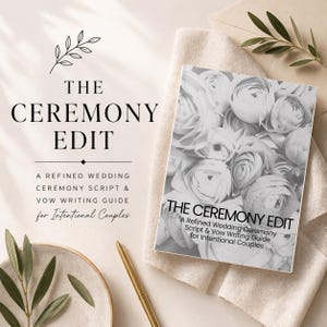 May include: A book titled "The Ceremony Edit" with a floral cover design, resting on a neutral-toned cloth. The book is a refined wedding ceremony script and vow writing guide for intentional couples. A gold pen and decorative plate are also visible.