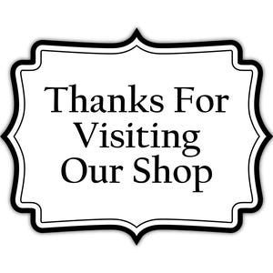 Op de afbeelding: Een wit, sierlijk gevormd bord met een zwarte rand. Het bord bevat de tekst "Thanks For Visiting Our Shop" in een klassiek schreeflettertype, perfect voor een winkelbericht.