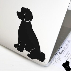May include: Black silhouette of a dog sitting on a white laptop. The laptop is open and has a business card on the right side with the text "Silhouette My Pet".