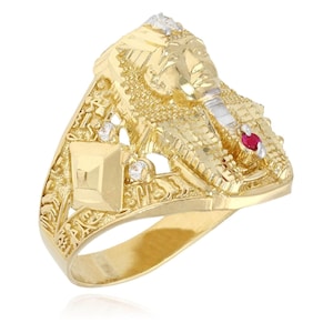Puede incluir: Un anillo dorado con un diseño de faraón egipcio. El anillo presenta una escultura detallada de la cabeza de un faraón, acentuada con pequeños diamantes y una gema roja. El anillo tiene una superficie intrincada y texturizada y un acabado pulido.