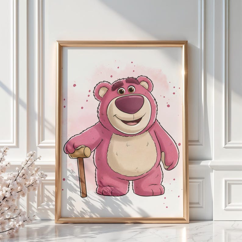 May include: A framed print featuring a cartoon illustration of a pink bear with a tan belly and a wooden mallet. The bear has a friendly expression and is set against a pink watercolor background. The frame is gold.