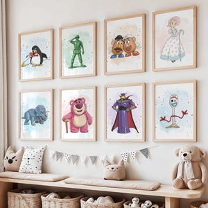 May include: Eight framed art prints featuring characters from the animated movie Toy Story. The prints include images of a penguin, a green soldier, Mr. and Mrs. Potato Head, Bo Peep, a blue dinosaur, Lotso, Zurg, and Forky. The prints are displayed on a white wall.