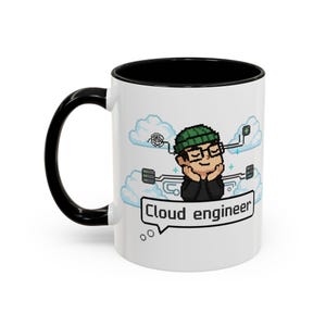 Könnte beinhalten: Weißer Keramikbecher mit schwarzem Innenraum und Henkel. Der Becher zeigt eine pixelige Illustration einer Person mit Brille und grüner Mütze, mit dem Text "Cloud engineer" in einer Sprechblase.