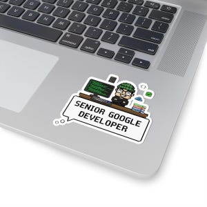 May include: A sticker showing a pixelated illustration of a person with glasses and a green beanie, seated at a desk with a computer monitor. The text "SENIOR GOOGLE DEVELOPER" is in a speech bubble.