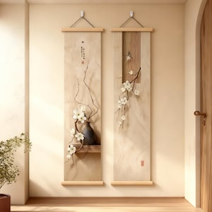 Puede incluir: Dos pergaminos verticales para pared con arte de inspiración asiática. Uno presenta un jarrón con flores blancas y ramas, el otro un pájaro y ramas. Ambos tienen tacos de madera y están colgados con cuerdas negras.