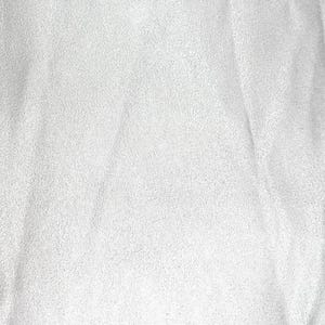 May include: A solid white fabric with a soft, matte, and slightly textured surface. The material displays subtle folds and creases that create gentle shadows across the surface, highlighting the uniform color and the fine, granular texture.