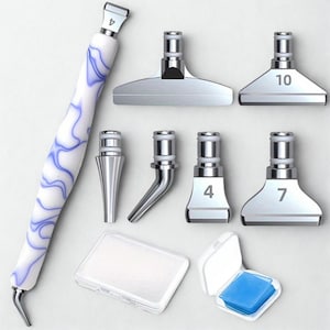Peut inclure: Un stylo pour peinture diamant avec un manche blanc et bleu marbré, accompagné de plusieurs embouts applicateurs argentés. Les embouts sont numérotés 4, 7 et 10. Deux petits contenants en plastique transparent sont également inclus.