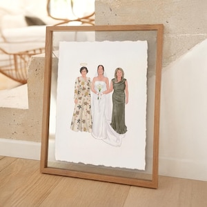 May include: A framed watercolour portrait depicting three women. The central figure is in a white strapless wedding gown and holds a bouquet. The woman on the left wears a floral dress, and the woman on the right wears a green dress. The artwork is in a wooden frame.