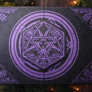 May include: Black and purple fantasy-themed box with a geometric design. The box features a large, central dodecahedron shape surrounded by concentric circles and corner accents. The design is in purple against a textured black background.