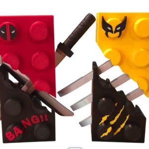 May include: Two Lego brick designs, superhero-themed. One features a red brick with a Deadpool mask and two katanas. The other has a yellow brick with a Wolverine mask and claw marks.