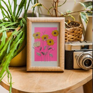 Blommigt risograftryck – A5 botanisk väggkonst, rosa bakgrund med gula blommor, begränsad upplaga