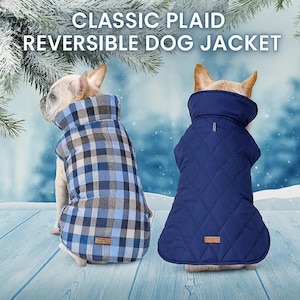 May include: Two dogs wearing reversible dog jackets. One jacket is blue and gray plaid, the other is a solid navy blue with a quilted pattern. The jackets have a high collar. The text at the top of the image reads "CLASSIC PLAID REVERSIBLE DOG JACKET."