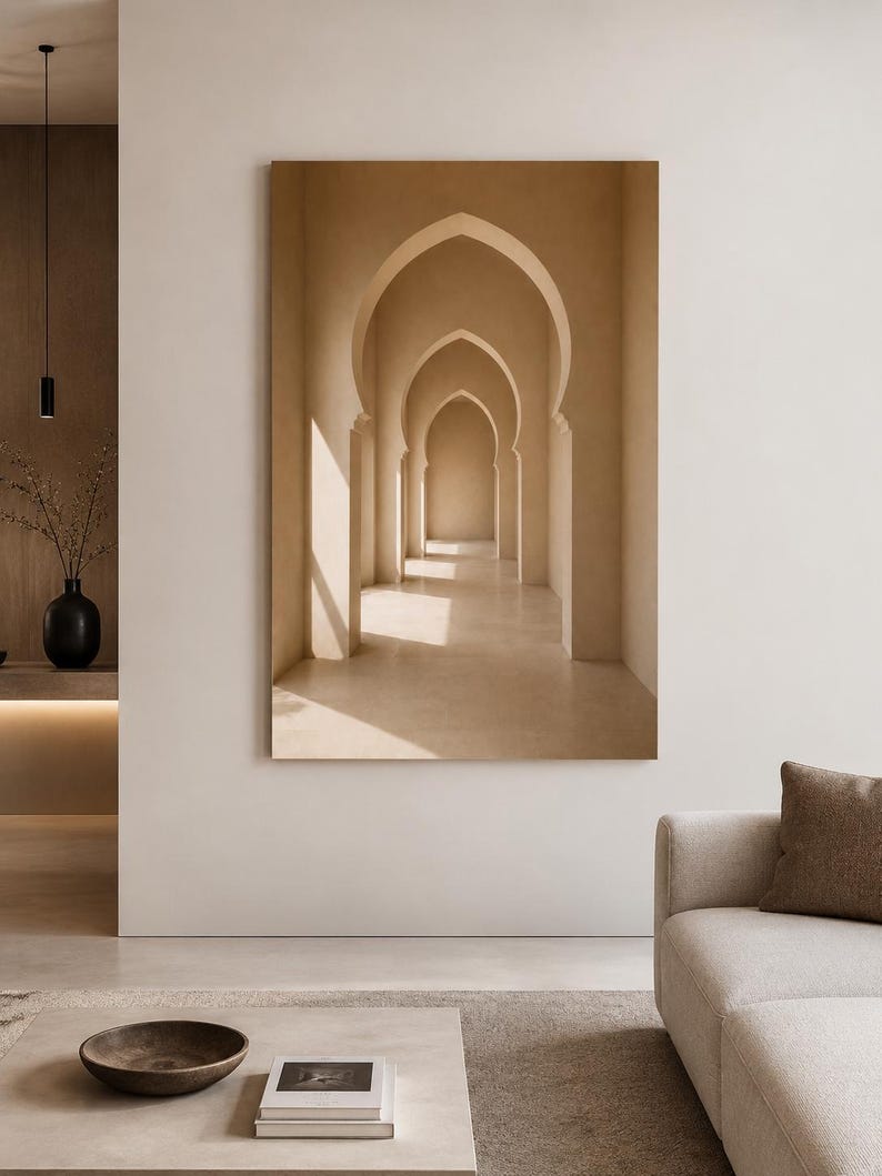 May include: A large rectangular wall art print featuring a series of beige, pointed archways receding into the distance. The image displays a warm, monochromatic color palette with soft sunlight casting distinct shadows across the floor and walls.
