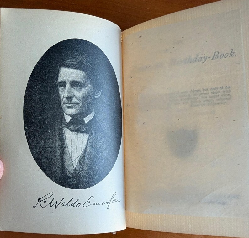 Puede incluir: Un libro abierto con un retrato en blanco y negro de un hombre con traje y pajarita. El texto "R. Waldo Emerson" est&aacute; debajo del retrato. La p&aacute;gina derecha tiene el texto "Birthday-Book."