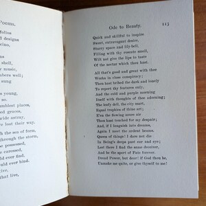 Puede incluir: Libro abierto con el poema "Ode to Beauty" impreso en la p&aacute;gina derecha. El texto est&aacute; en tinta negra sobre papel envejecido blanquecino. El n&uacute;mero de p&aacute;gina "113" es visible. La p&aacute;gina izquierda contiene una lista de palabras.