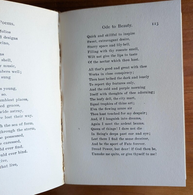 Puede incluir: Libro abierto con el poema "Ode to Beauty" impreso en la p&aacute;gina derecha. El texto est&aacute; en tinta negra sobre papel envejecido blanquecino. El n&uacute;mero de p&aacute;gina "113" es visible. La p&aacute;gina izquierda contiene una lista de palabras.