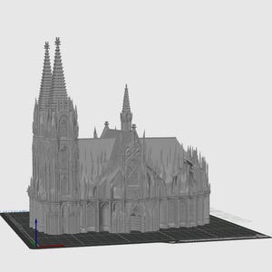 Op de afbeelding: Een grijs 3D-model van een kathedraal, met gedetailleerde architectonische kenmerken. Het model staat op een donkergrijze basis. De kathedraal heeft twee hoge torens en verschillende kleinere torens.