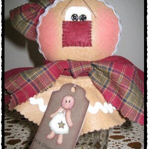 May include: A gingerbread person doll with a plaid fabric skirt and a tag that says "Prim Ginger Blessings".