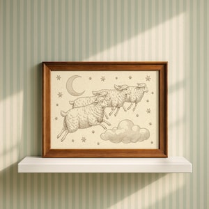May include: A framed print featuring a line drawing of three sheep leaping over a cloud against a cream background. The illustration includes a crescent moon and several small stars. The frame is made of medium-toned brown wood.