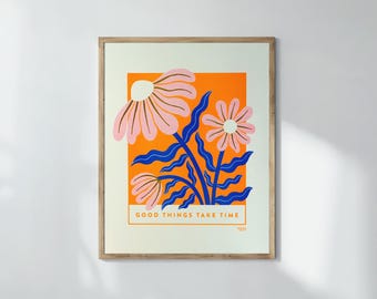 May include: A framed art print with a floral design. The artwork features pink flowers with orange and blue accents. The text "GOOD THINGS TAKE TIME" is at the bottom of the print. The print is in a wooden frame.
