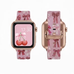 Puede incluir: Smartwatch de oro rosa con una correa rosa estampada con lazos. La esfera del reloj muestra la hora 17:30 y un gráfico de cerezas. La correa está sujeta al reloj con un cierre de oro rosa.