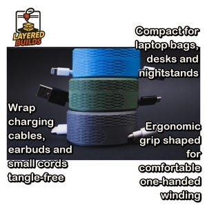 May include: Three cylindrical cable organizers stacked vertically in blue, olive green, and dark gray. Each features a textured diamond pattern on the side and slots for winding cables. Text on the image reads: Layered Builds, Compact for laptop bags, desks and nightstands, Wrap charging cables, earbuds and small cords tangle-free, Ergonomic grip shaped for comfortable one-handed winding.