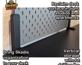 May include: A black L-shaped desk clamp mount supporting a gray pegboard panel. The image includes the text: Layered Builds, Reclaim desk surface in tight studios and apartments, Bring Skadis organization to your desk edge, Vertical storage without drilling the wall.